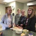 A group of confirmation students making sandwiches.